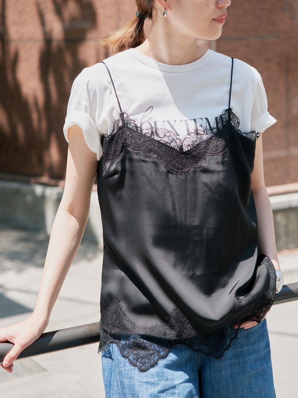 ブルー系のデニムパンツ、ブラック系のキャミソール、ホワイト系のTシャツ/カットソーを着用したレディースの春コーディネートの3枚目の写真
