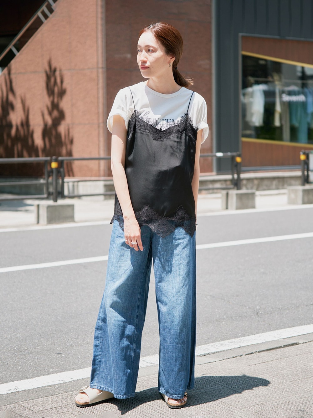 ブルー系のデニムパンツ、ブラック系のキャミソール、ホワイト系のTシャツ/カットソーを着用したレディースの春コーディネートの1枚目の写真