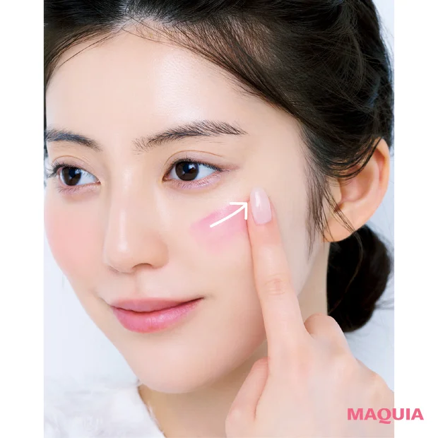 リキッドチークを人差し指で頬の内から外へ塗っているモデル